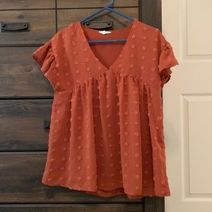 Small orange blouse worn once with polka dots. Fluttered sleeves and low cut.